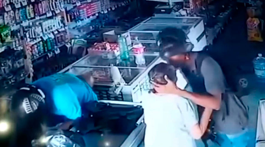 Un ladrón armado besa a una anciana durante un asalto a una tienda y rehusa robarle su dinero
